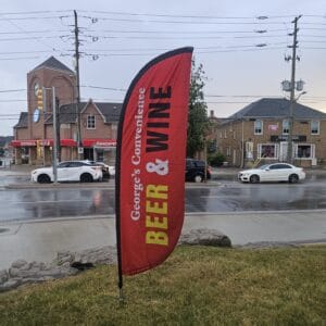 Custom printed feather flag installed outdoors