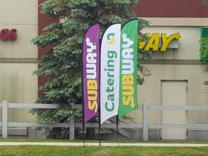 Three feather flags standing on a lawn outside a restaurant