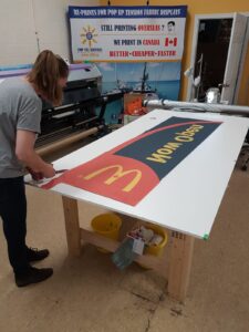Printed feather flag fabric laid out on a cutting table
