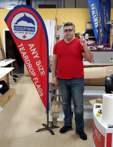 Red and blue teardrop flag on a cross base in a print shop