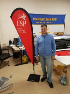 Red teardrop flag on a square steel base in a print shop