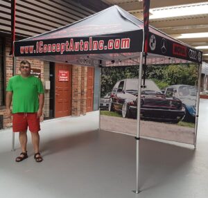 Pop-up tent with a black printed canopy edge and a photo-printed back wall, indoors