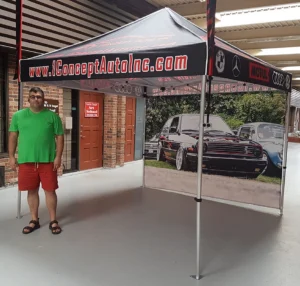 Pop-up tent with a black printed canopy edge and a photo-printed back wall, indoors