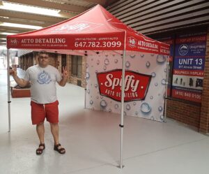 Red printed canopy tent with a printed back wall, indoors