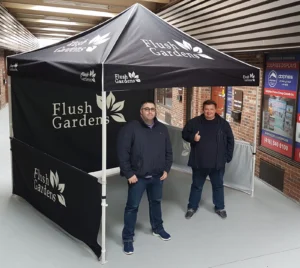 Black printed canopy tent with printed walls on the back and both sides, indoors