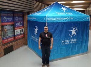 Blue printed canopy tent closed with printed walls on three sides, indoors