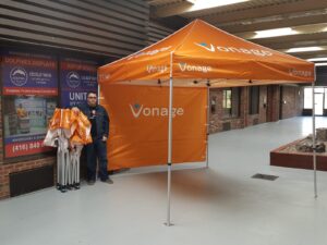 Orange printed canopy tent with an orange printed back wall, indoors