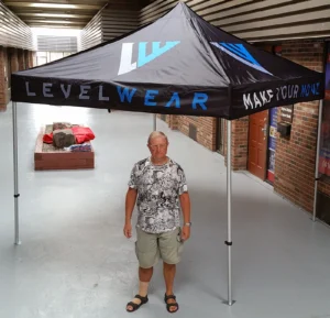 Black printed canopy tent with blue lettering, indoors