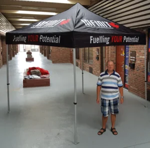 Black printed canopy tent with orange lettering, indoors