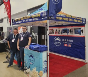 Trade show booth under a printed canopy tent with a printed counter