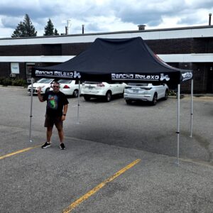 Black printed canopy tent with white lettering in a parking lot