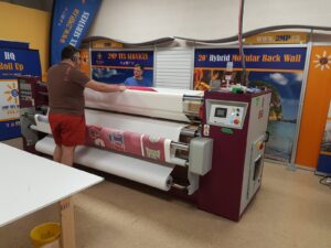 Canopy fabric running through a dye-sublimation heat press
