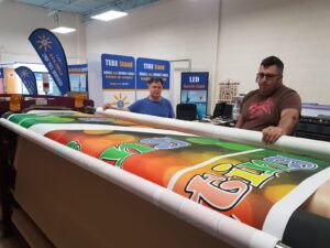 Colourful printed canopy fabric being trimmed on a work table