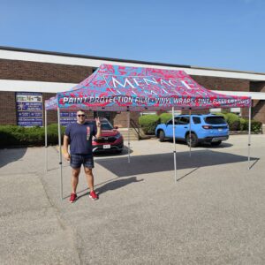 Pink and blue printed canopy tent set up in a parking lot