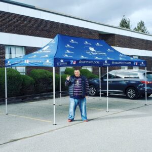 Blue printed canopy tent set up in a parking lot