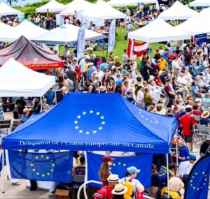 Navy printed canopy tent with a printed back wall among white tents at a crowded outdoor event