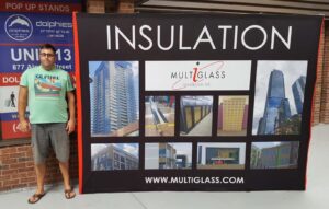 Man beside a black 10 ft pop up fabric display with building photos and the word insulation