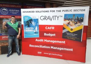 Man beside a red and white 10 ft pop up fabric display with software screenshots