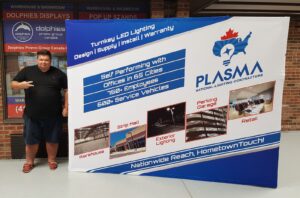 Man beside a white 10 ft pop up fabric display with a blue map and a red maple leaf