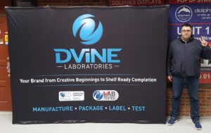 Man beside a navy 10 ft pop up fabric display with a large blue logo