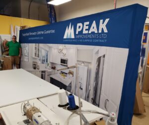 Man beside a 16 ft pop up fabric display with a kitchen photo in the workshop