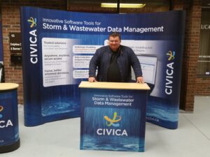 Man behind a blue pop up fabric counter in front of a matching curved display