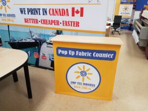 Yellow pop up fabric counter with a sun logo in the showroom