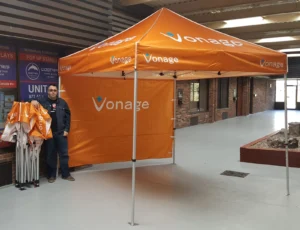Orange printed canopy tent with an orange printed back wall, indoors