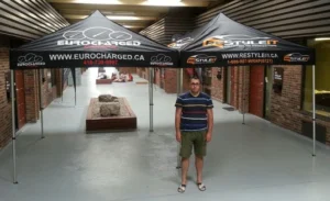 Two black printed canopy tents side by side, indoors