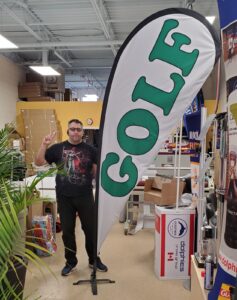 White custom printed teardrop flag with green lettering on a cross base