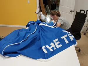 Sewing station finishing a blue printed fabric graphic
