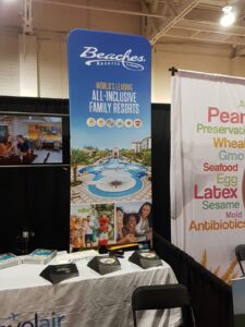 A 3 ft tube fabric display with a tropical resort graphic at a trade show booth