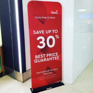 Red a 3 ft tube fabric display with large white text at a store entrance