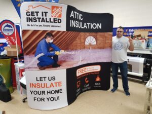Man beside an 8 ft curved tube fabric display with a home insulation photo