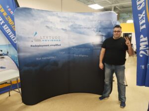 Man beside an 8 ft curved tube fabric display with a sky gradient graphic