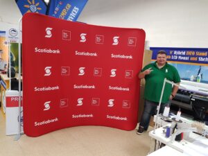 Man beside a red step-and-repeat an 8 ft curved tube fabric display