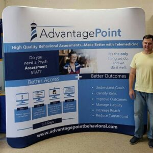 Man beside an 8 ft curved tube fabric display with blue headers and white panels