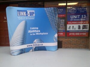 Blue an 8 ft curved tube fabric display with a city skyline graphic