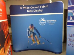 Blue an 8 ft curved tube fabric display with a skier graphic in the showroom